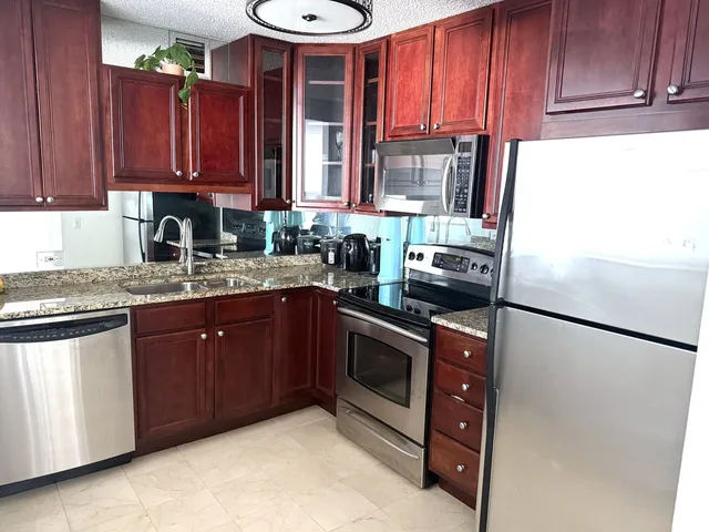 a kitchen with stainless steel appliances granite countertop a refrigerator stove a sink and dishwasher