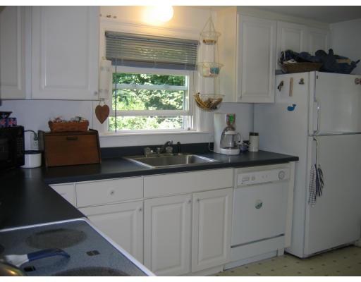 28 Edgewood Road Concord, MA 01742 - Photo 4 of 6 a kitchen with stainless steel appliances granite countertop a refrigerator sink and white cabinets