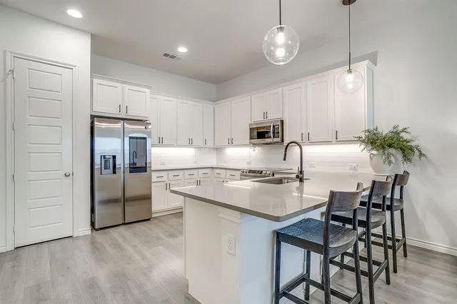a kitchen with refrigerator cabinets and chairs