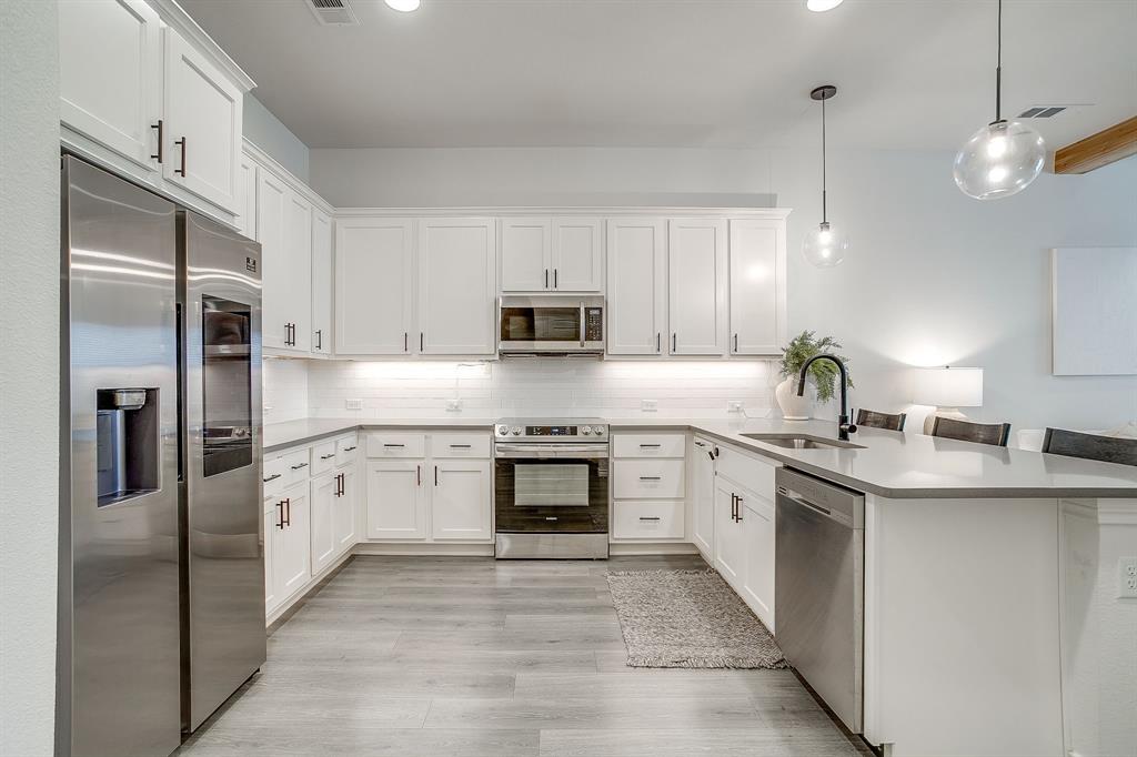 2829 Stanley Avenue Fort Worth, TX 76110 - Photo 12 of 40 a kitchen with stainless steel appliances granite countertop a refrigerator a stove top oven a sink and dishwasher
