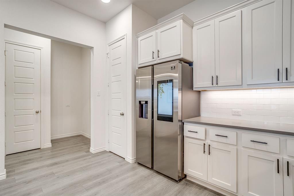 2829 Stanley Avenue Fort Worth, TX 76110 - Photo 13 of 40 a kitchen with white cabinets and refrigerator