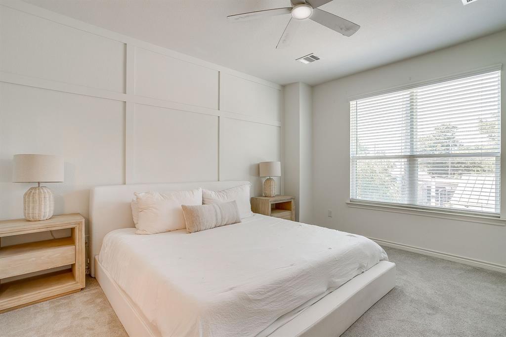 2829 Stanley Avenue Fort Worth, TX 76110 - Photo 15 of 40 a bedroom with a large bed and a chandelier fan