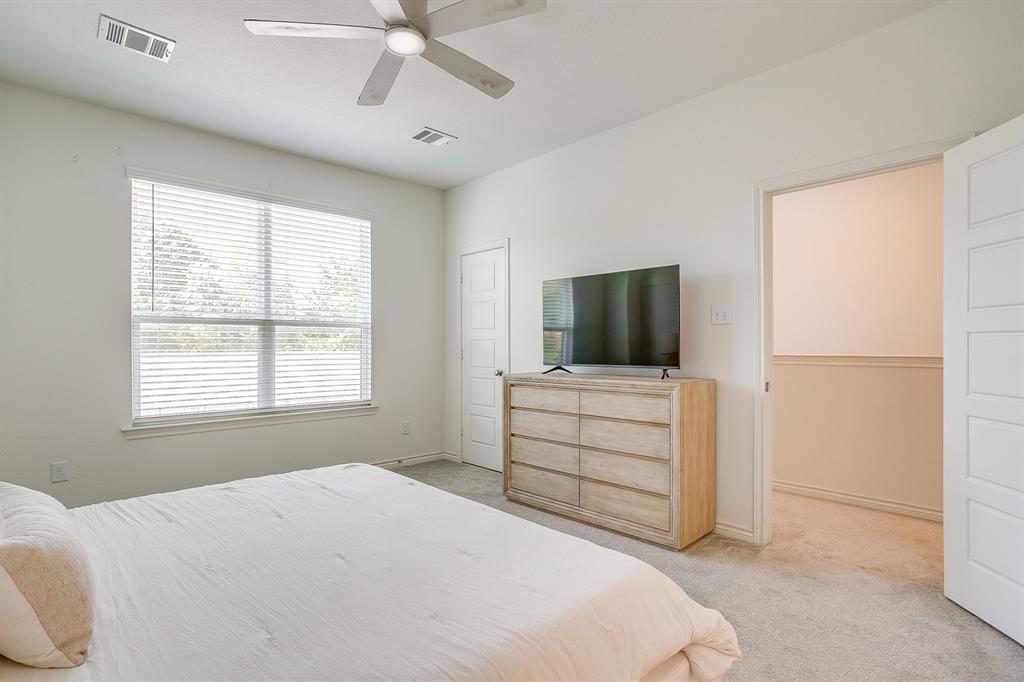 2829 Stanley Avenue Fort Worth, TX 76110 - Photo 18 of 40 a bedroom with a bed and a flat screen tv