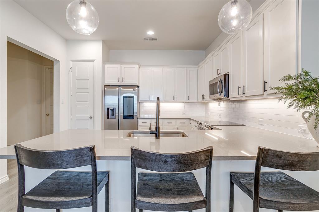 2829 Stanley Avenue Fort Worth, TX 76110 - Photo 10 of 40 a kitchen with kitchen island granite countertop a table chairs sink and cabinets
