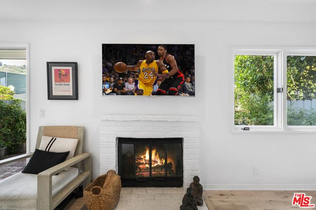 a living room with furniture a fireplace and wall painting