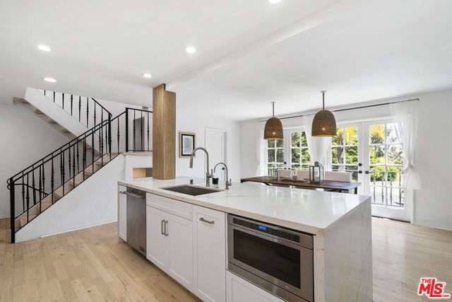 a kitchen with stainless steel appliances a sink a stove and a wooden floors