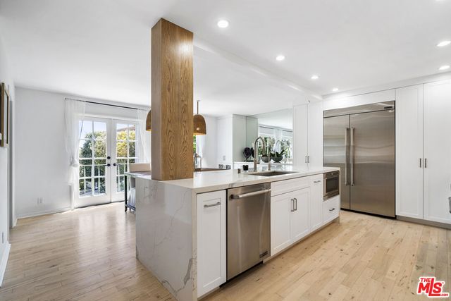 a kitchen with stainless steel appliances a kitchen island hardwood floor sink and stove