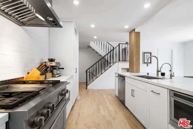 a kitchen with sink a stove and cabinets