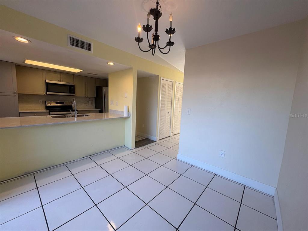 4033 Henley Road, Unit 1707 Orlando, FL 32839 - Photo 35 of 66 a kitchen with kitchen island granite countertop a refrigerator and a stove top oven