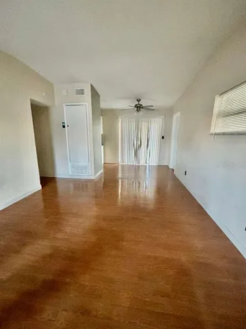 a view of empty room with wooden floor