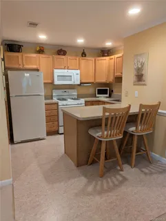 a kitchen with stainless steel appliances a refrigerator a stove a sink dishwasher with a dining table and chairs