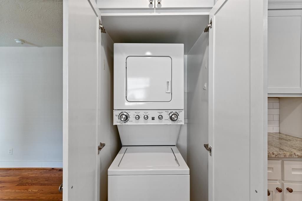 1305 Idylwild Street Houston, TX 77009 - Photo 17 of 31 This photo shows a compact, stackable washer and dryer unit neatly tucked into a closet, maximizing space efficiency in the home.