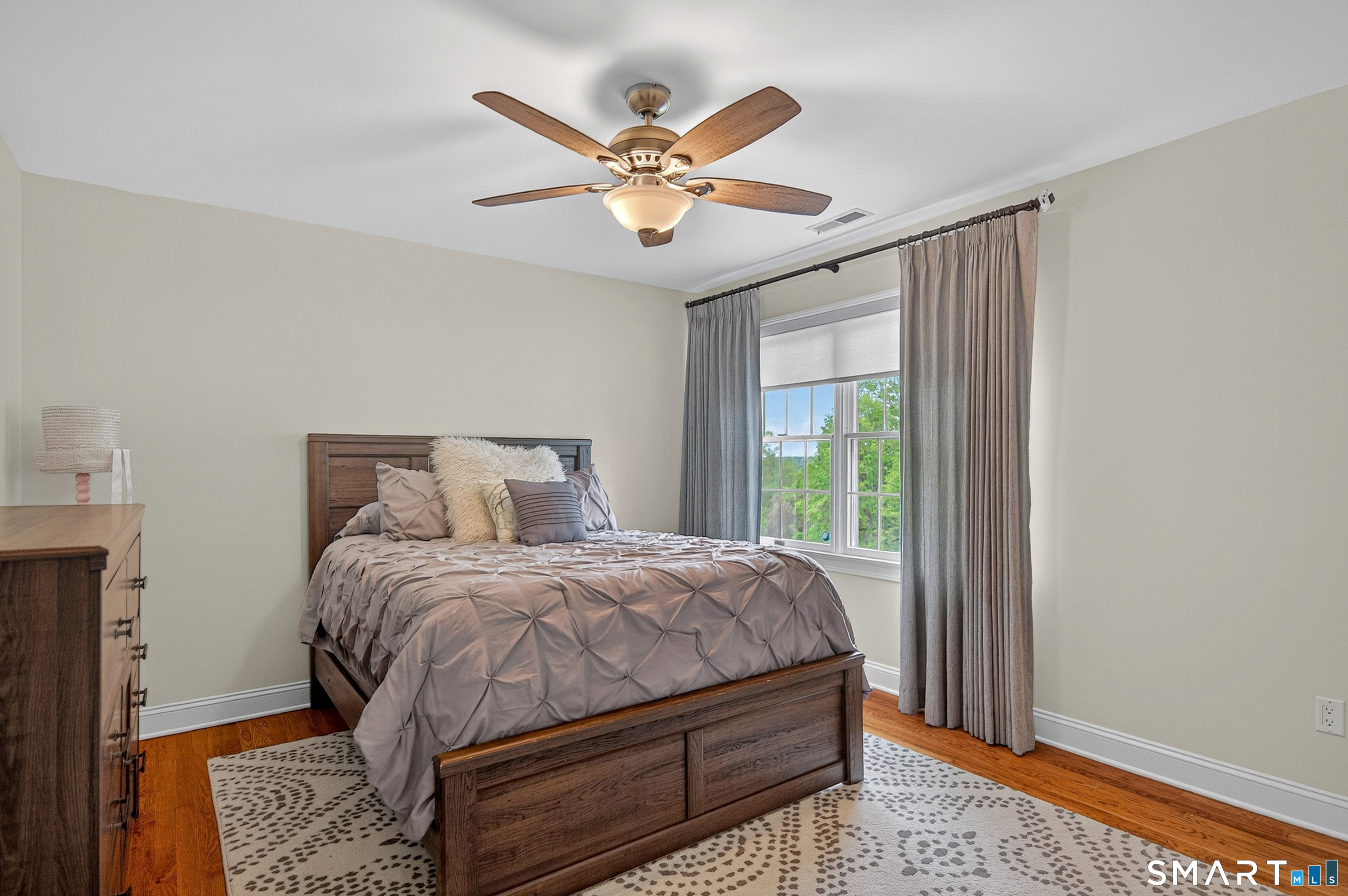 16 Farm Meadow Road Newtown, CT 06470 - Photo 20 of 40 Comfortable secondary bedroom with hardwood floors, ceiling fan, and oversized window overlooking the property.