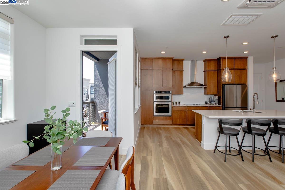 2885 Tradewind Drive Alameda, CA 94501 - Photo 5 of 12 a kitchen with a table chairs refrigerator and microwave
