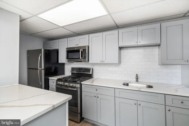 a kitchen with white cabinets sink and stainless steel appliances