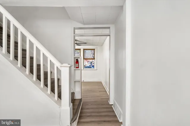 a view of a hallway with wooden floor and staircase