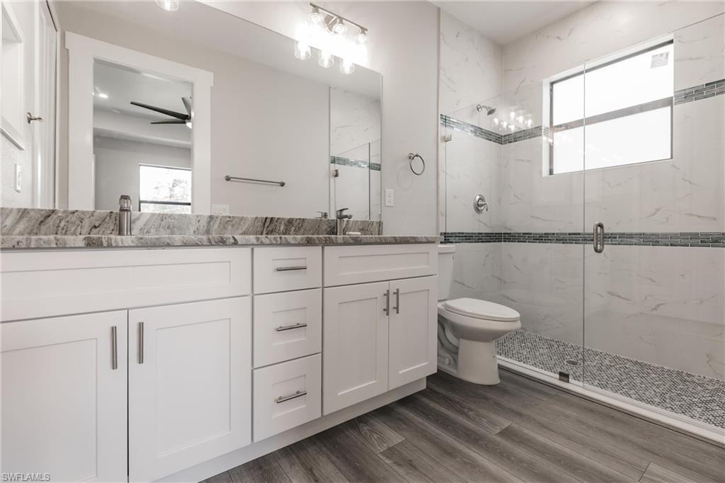 26395-26397 Explorer Road Punta Gorda, FL 33983 - Photo 11 of 18 a bathroom with a granite countertop sink mirror and a toilet