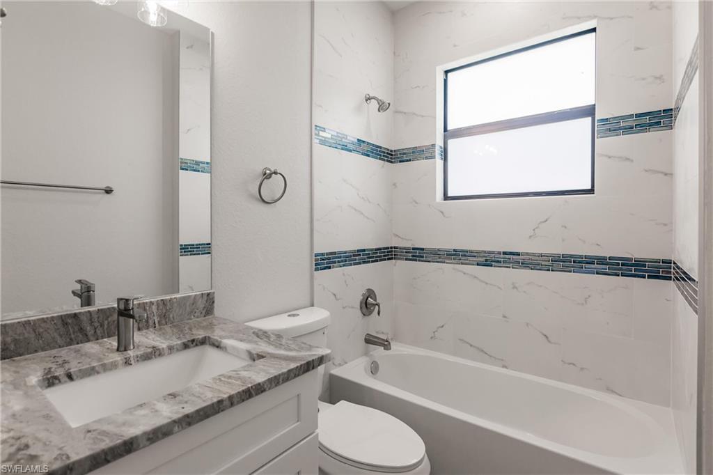 26395-26397 Explorer Road Punta Gorda, FL 33983 - Photo 13 of 18 a bathroom with a granite countertop sink mirror toilet and bathtub