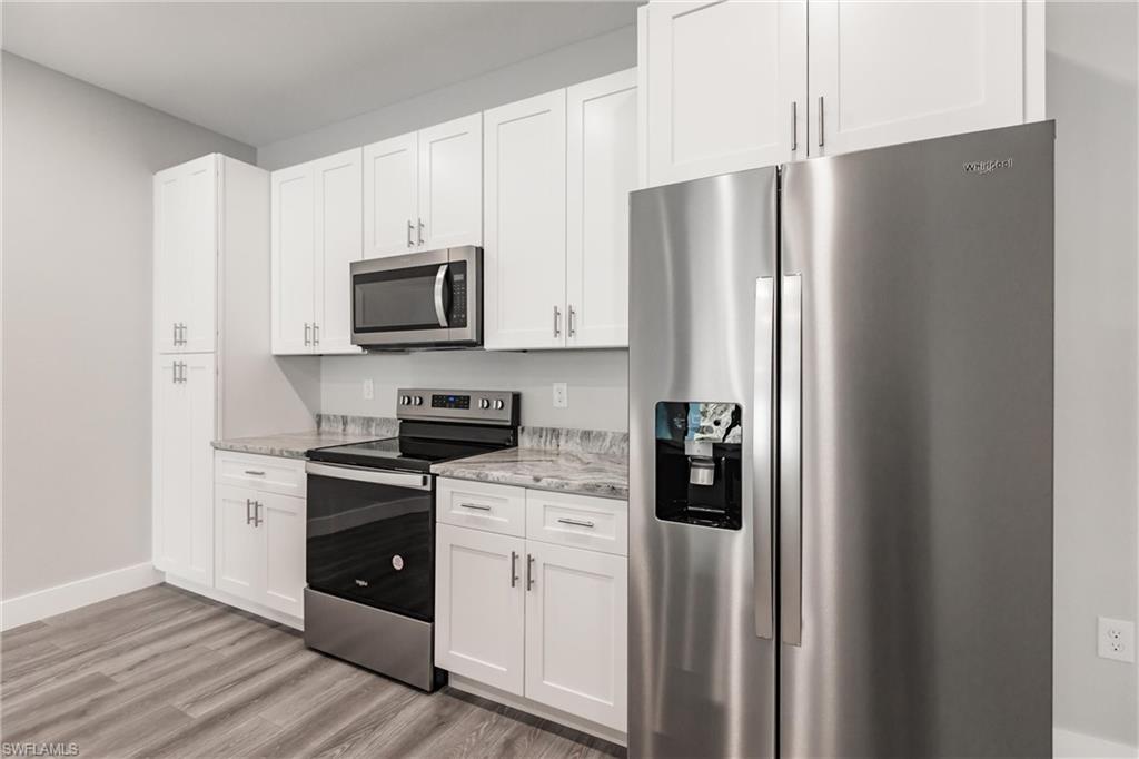 26395-26397 Explorer Road Punta Gorda, FL 33983 - Photo 4 of 18 a kitchen with stainless steel appliances white cabinets and a refrigerator