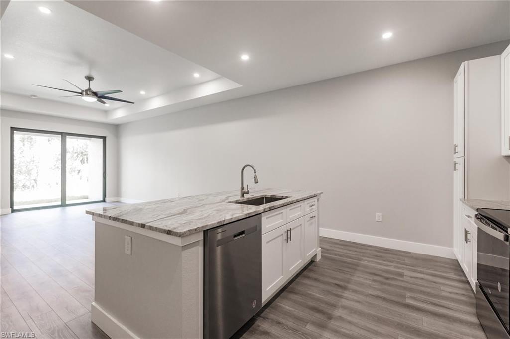 26395-26397 Explorer Road Punta Gorda, FL 33983 - Photo 5 of 18 a kitchen with stainless steel appliances granite countertop a sink a stove and a wooden floors
