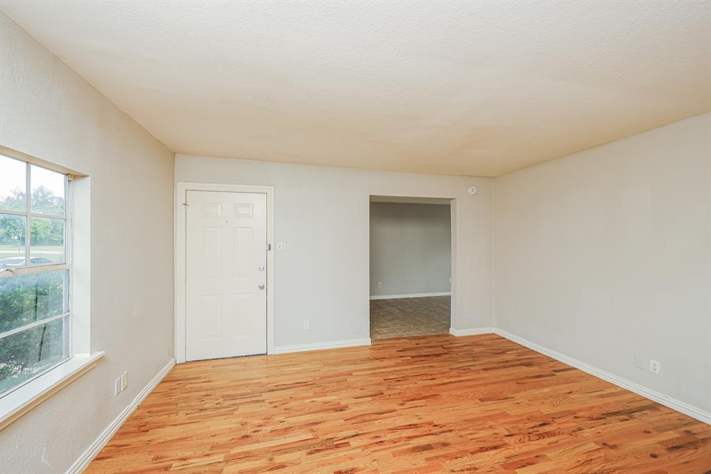 5175 Cardiff Street Dallas, TX 75241 - Photo 12 of 16 Living area featuring hardwood floors, light-colored walls, and a window with an exterior view