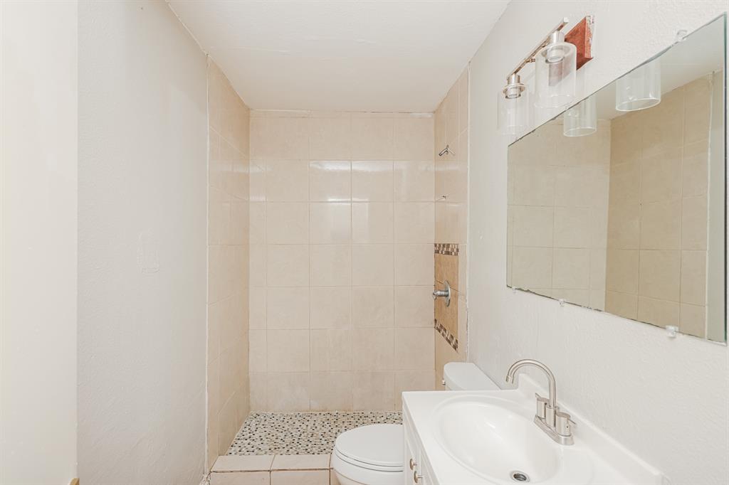 5175 Cardiff Street Dallas, TX 75241 - Photo 14 of 16 The bathroom features tiled walls and a vanity with a mirror and light fixture