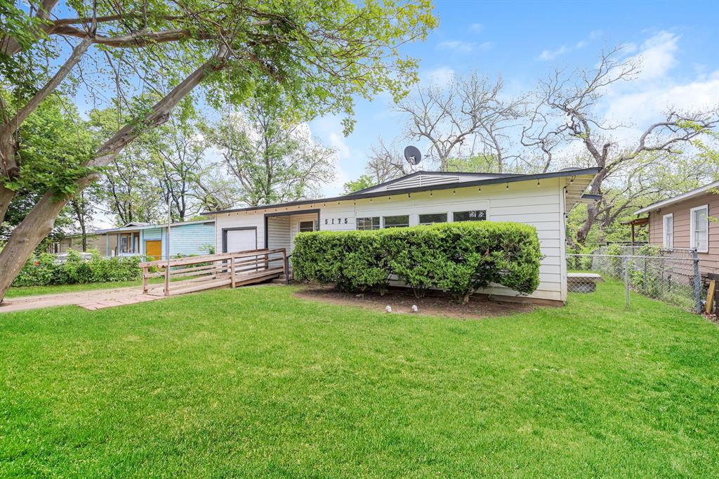 5175 Cardiff Street Dallas, TX 75241 - Photo 2 of 16 The property features a well-maintained lawn, mature trees, and a wooden access ramp leading to the front entrance