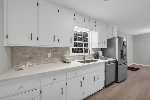 a kitchen with stainless steel appliances white cabinets and a refrigerator