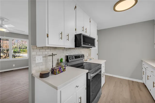 a kitchen with granite countertop a sink a stove and wooden cabinets