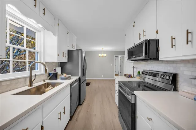a kitchen with stainless steel appliances granite countertop a sink stove and refrigerator