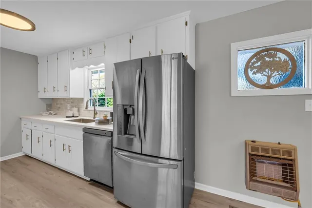 a kitchen with stainless steel appliances a refrigerator and a stove top oven