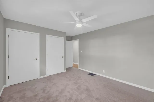 an empty room with a ceiling fan and a window