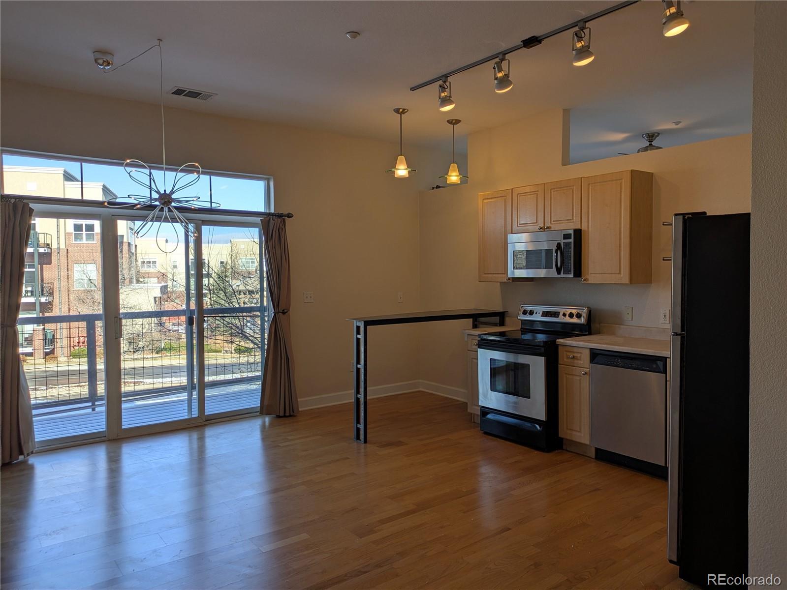 5677 South Park Place, Unit C204 Englewood, CO 80111 - Photo 2 of 13 a kitchen with stainless steel appliances kitchen island granite countertop a refrigerator and a stove top oven