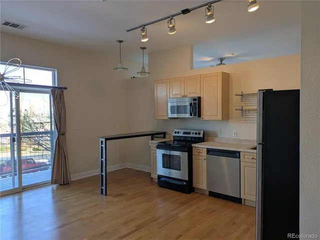 a kitchen with stainless steel appliances granite countertop a stove a sink and a refrigerator