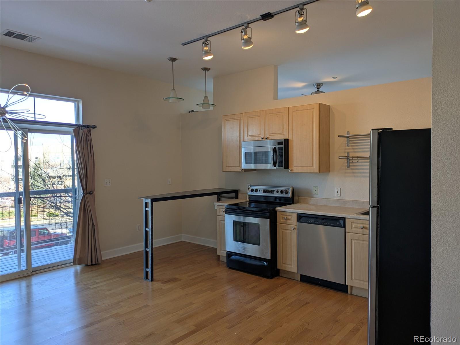 5677 South Park Place, Unit C204 Englewood, CO 80111 - Photo 3 of 13 a kitchen with stainless steel appliances granite countertop a stove a sink and a refrigerator