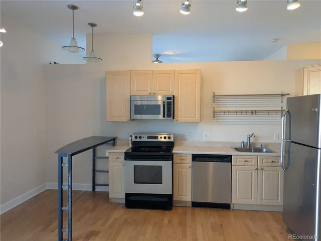a kitchen with a sink a microwave a stove and refrigerator