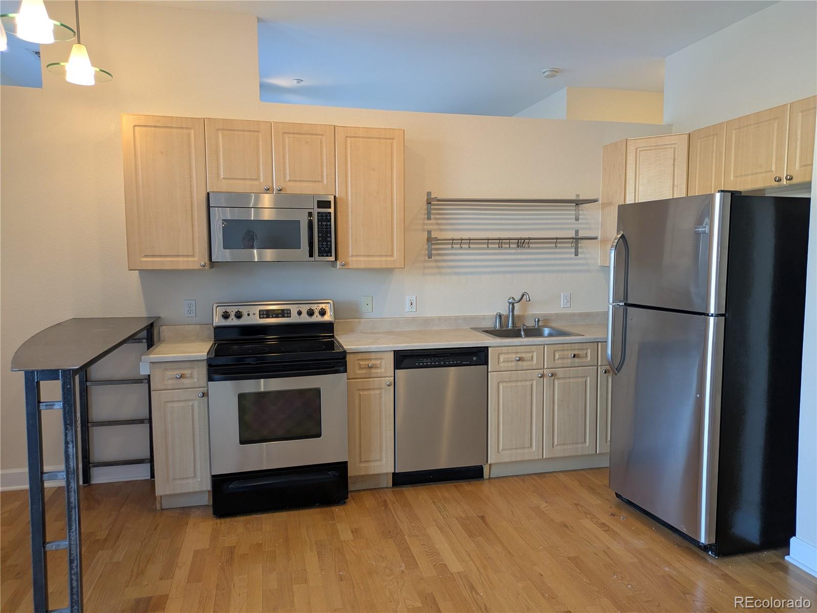 5677 South Park Place, Unit C204 Englewood, CO 80111 - Photo 5 of 13 a kitchen with stainless steel appliances a refrigerator stove and microwave