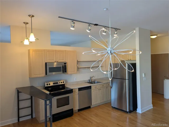 a kitchen with stainless steel appliances a stove a refrigerator and a clock