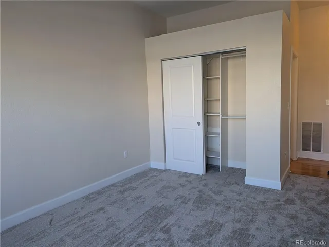 an empty room with closet and mirror