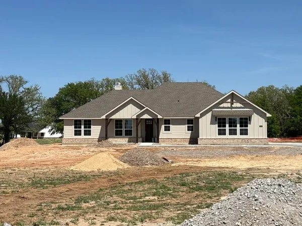 a front view of a house with a yard covered with trees