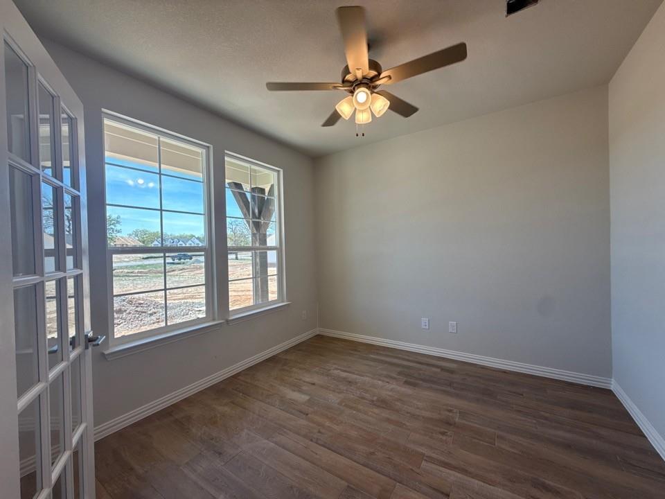 156 Oak Grv Way Springtown, TX 76082 - Photo 5 of 17 a view of an empty room with wooden floor and a window
