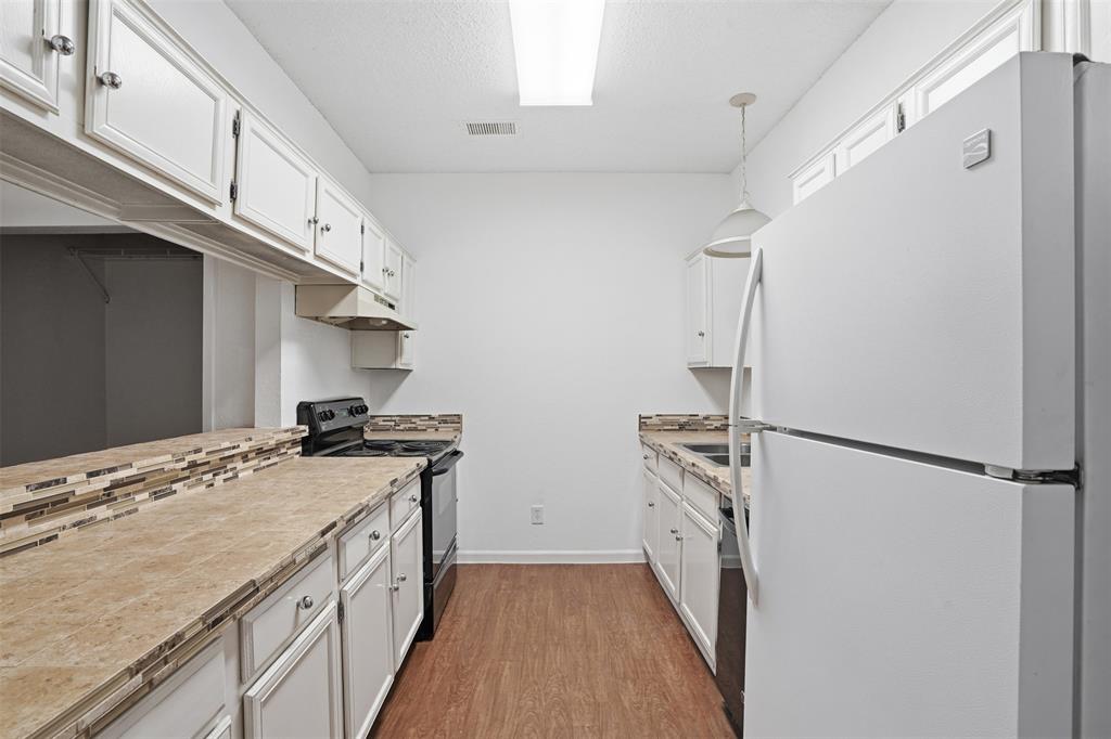 5550 Spring Valley Road, Unit F14 Dallas, TX 75254 - Photo 6 of 15 a kitchen with a stove a refrigerator and a stove