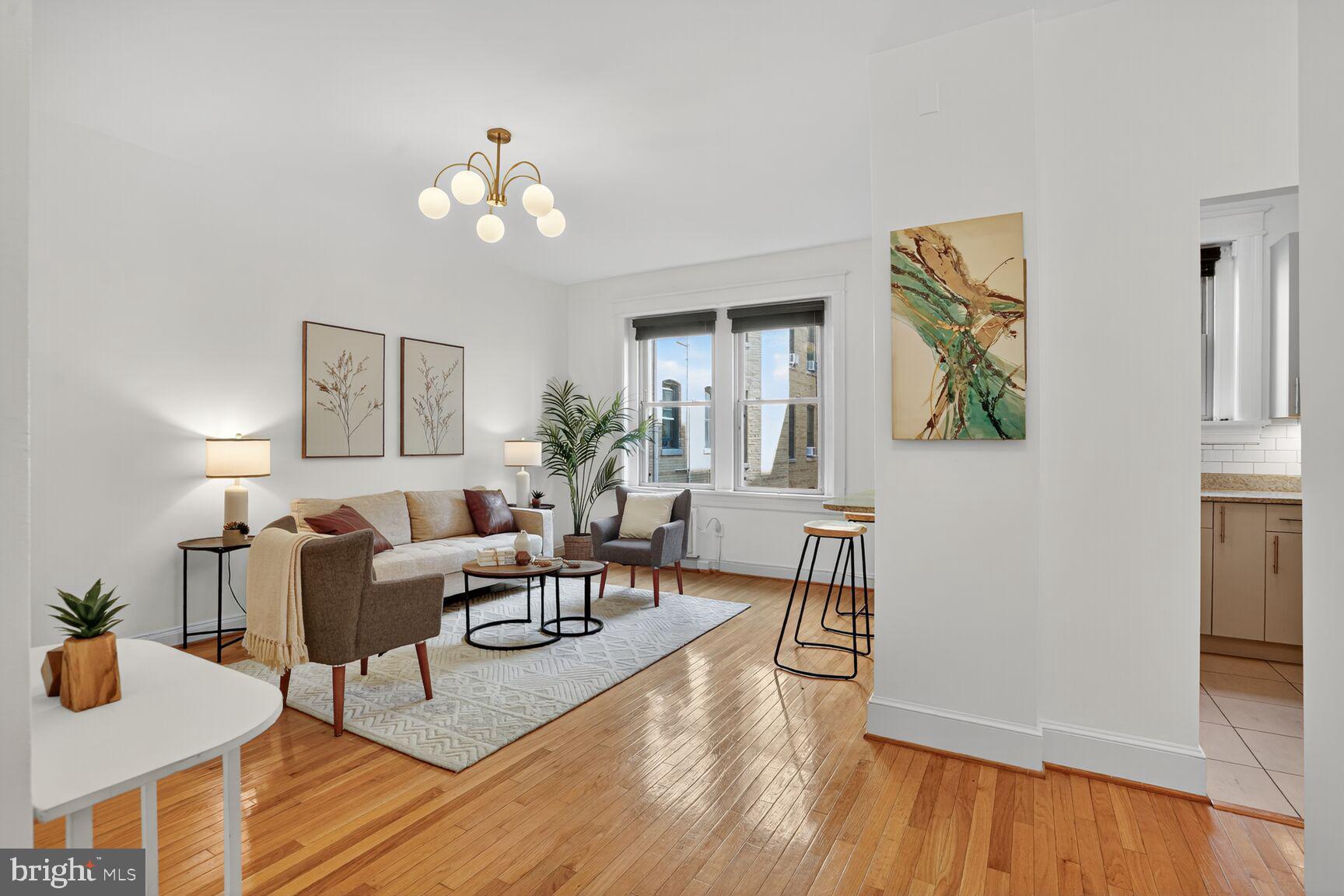 a living room with couches and a dining table with wooden floor