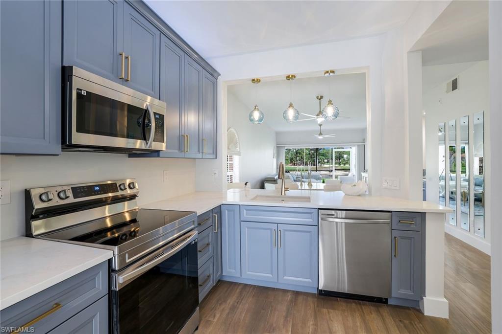 555 Augusta Boulevard, Unit 31 Naples, FL 34113 - Photo 8 of 17 a kitchen with stainless steel appliances a stove microwave and sink