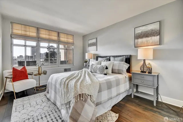 a bedroom with a bed and a couch next to a window