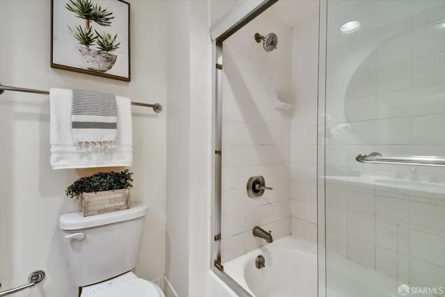 a bathroom with a shower a toilet and a sink