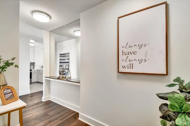 a view of a hallway with wooden floor and a workspace