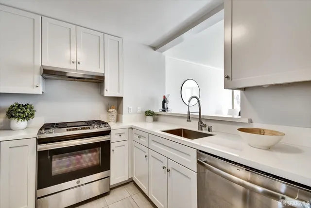 a kitchen with appliances a sink and cabinets