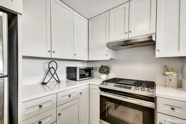 a kitchen with white cabinets and appliances