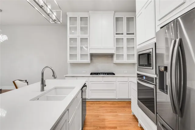 a kitchen with stainless steel appliances granite countertop a sink stove and refrigerator
